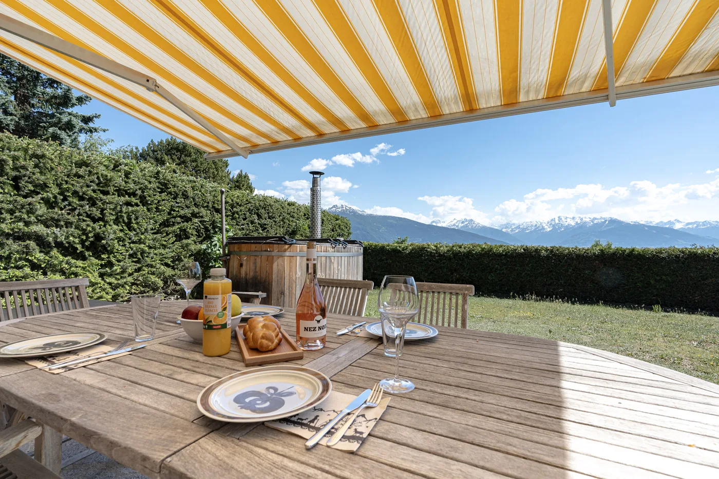 Terrasse ensoleillée avec store d'un chalet en location courte durée à Crans-Montana