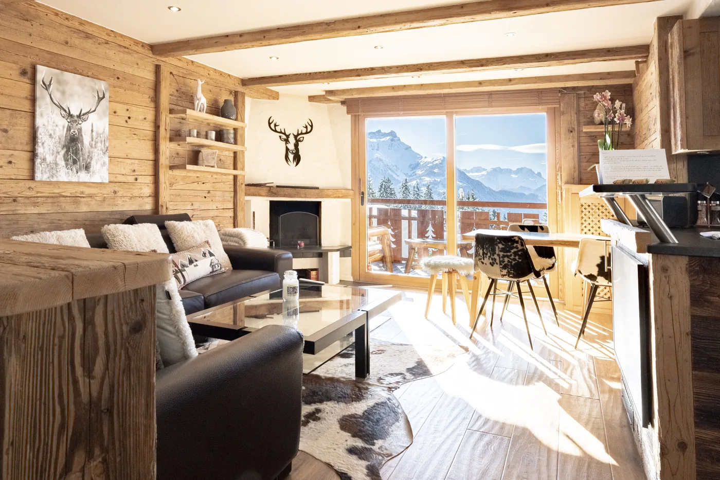 Salon avec cheminée et tête de cerf décorative d'un chalet en gestion locative