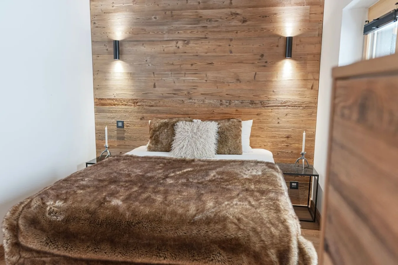 Old-wood bedroom with double bed and fur throw, holiday apartment in Villars