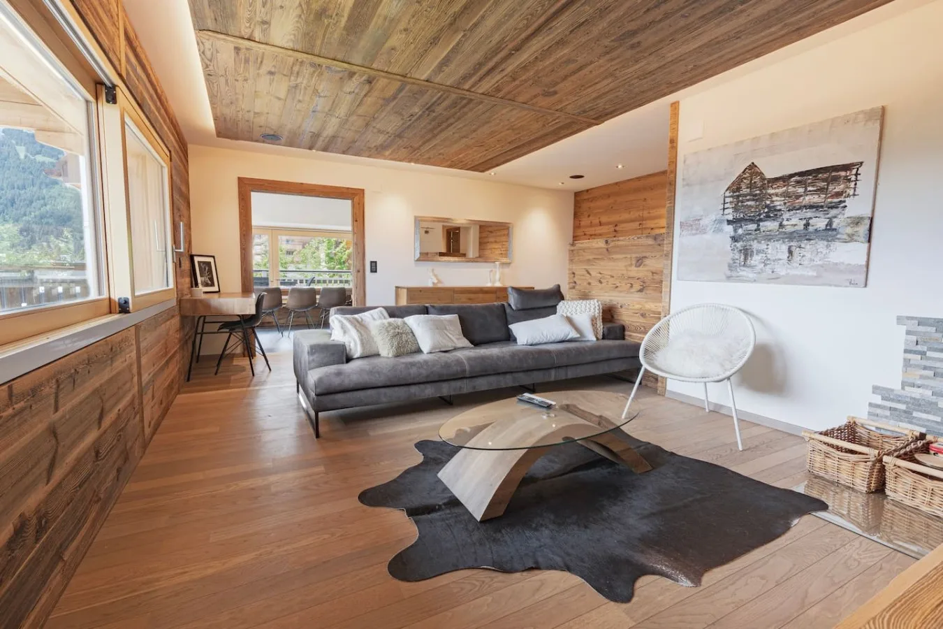 Old-wood living room with leather sofa, cowhide and bay windows, Villars-sur-Ollon