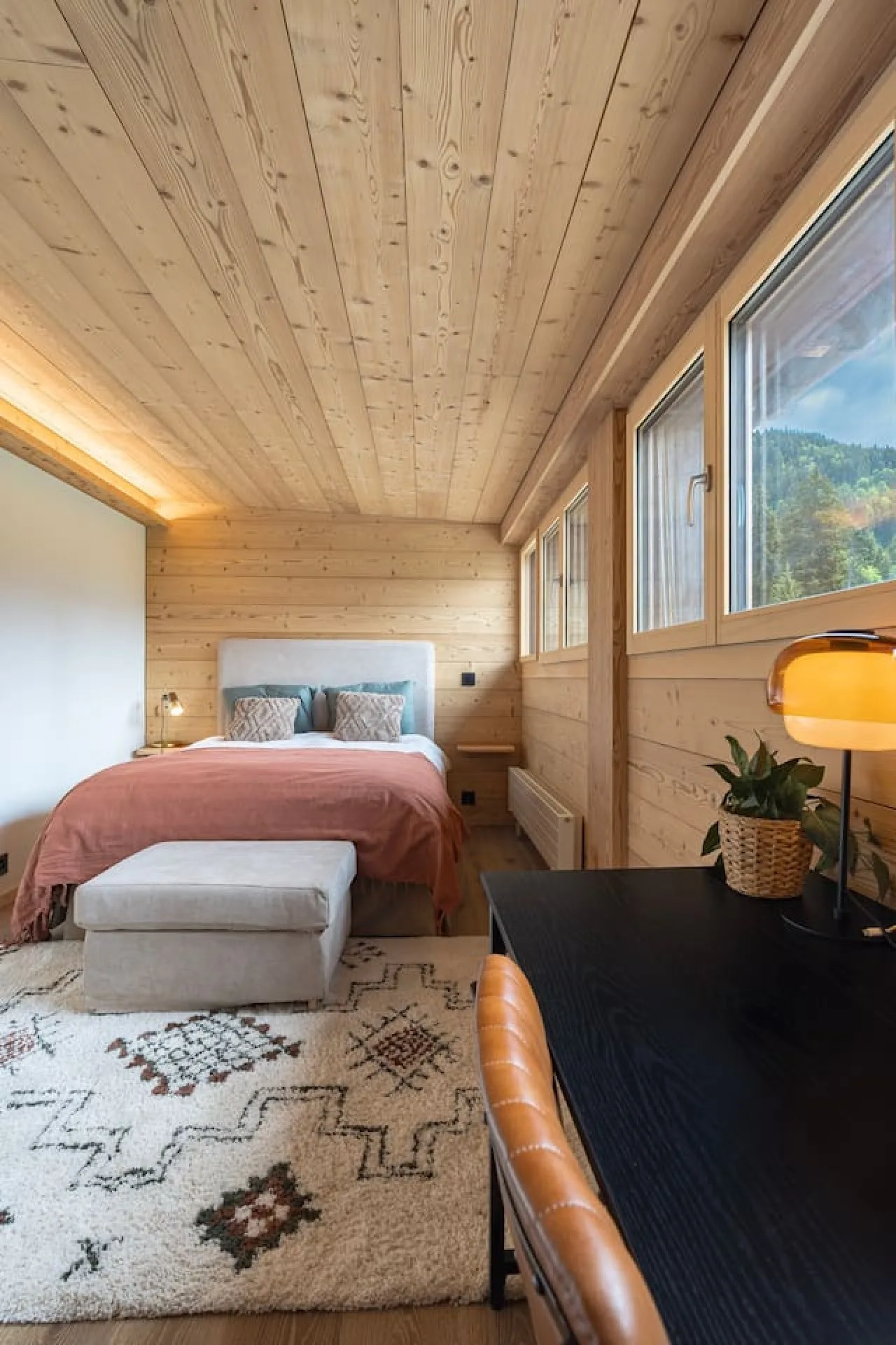Main bedroom of the penthouse with double bed and pink bedspread, Villars-sur-Ollon