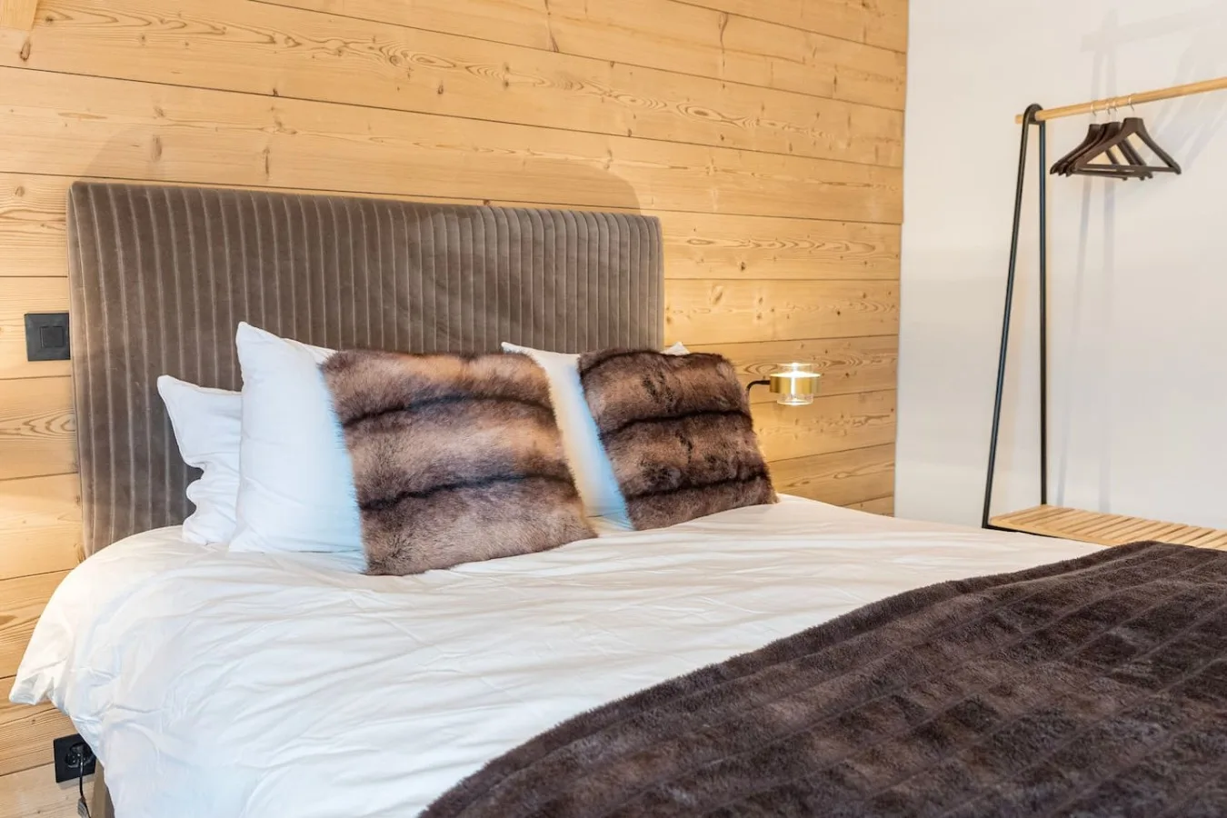 Panelled bedroom with double bed and fur throws, penthouse in Villars