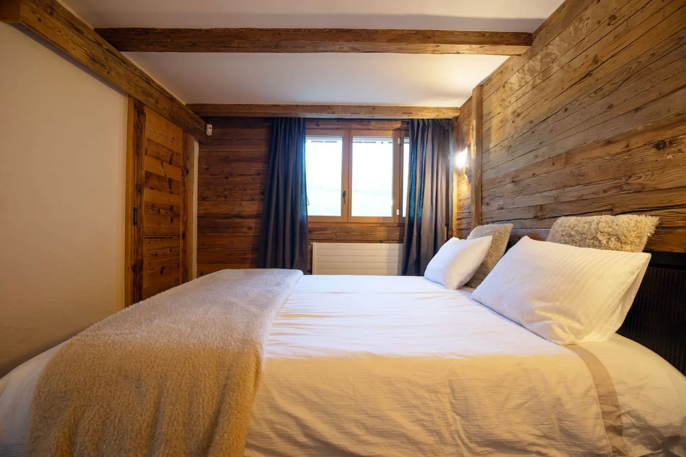 Large open bedroom with bed and old wood, apartment near the slopes in Villars-sur-Ollon