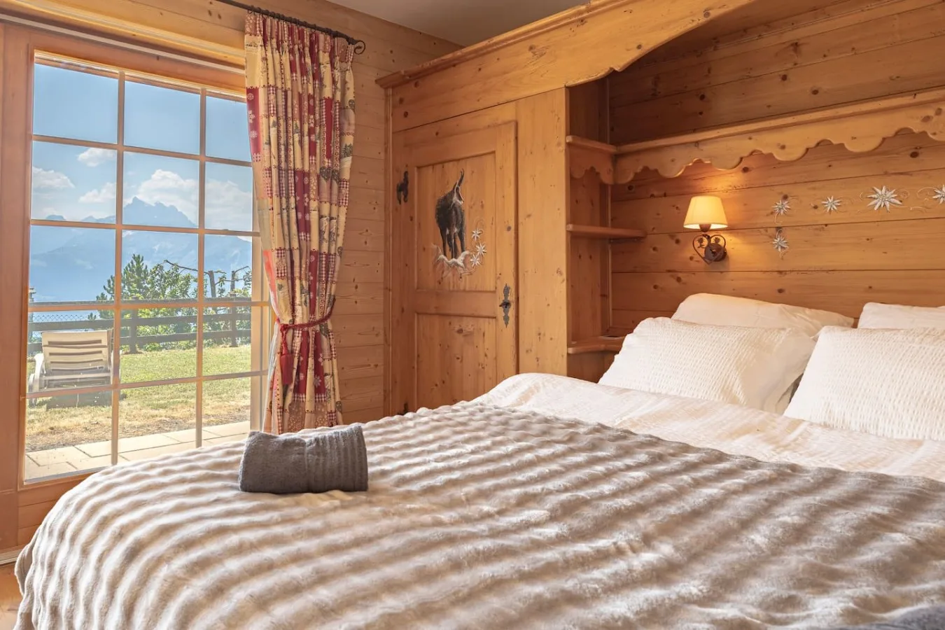 Panelled bedroom with large bed, garden-level apartment in Villars-sur-Ollon
