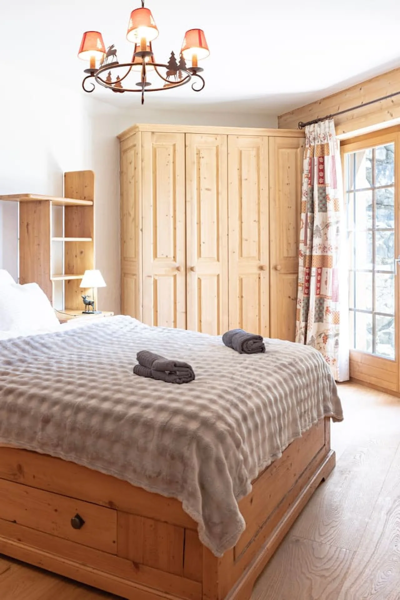 Third bedroom with large bed and curtains, garden-level apartment in Villars