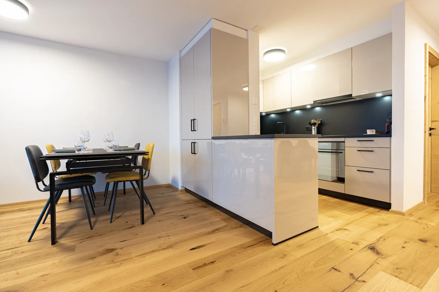 Séjour avec table à manger et cuisine ouverte d'un appartement en location courte durée à Ovronnaz