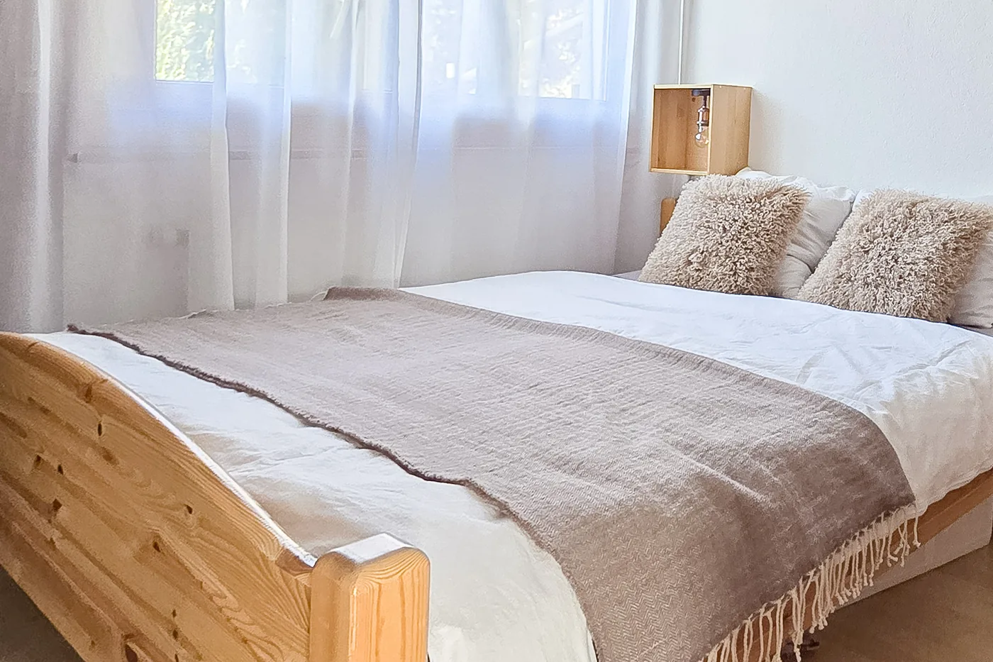 Chambre double en bois clair d'un appartement en gestion locative