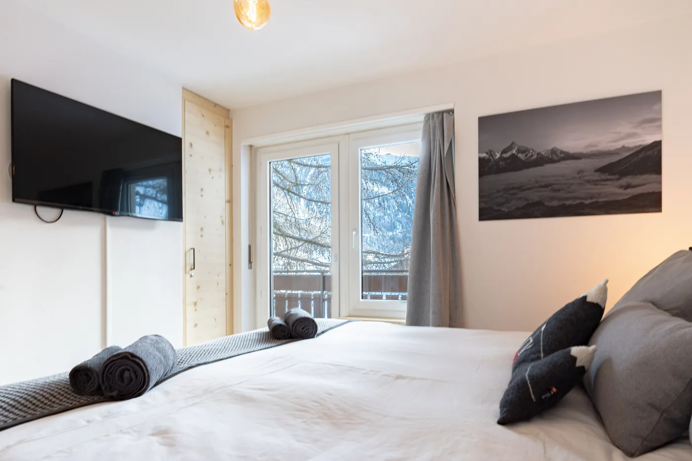 Chambre avec TV et balcon d'un appartement en gestion locative