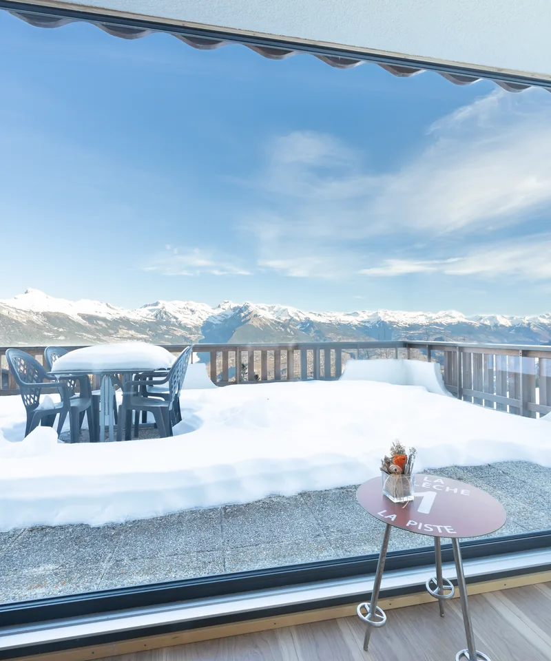 Baie vitrée avec terrasse enneigée d'un appartement en gestion locative