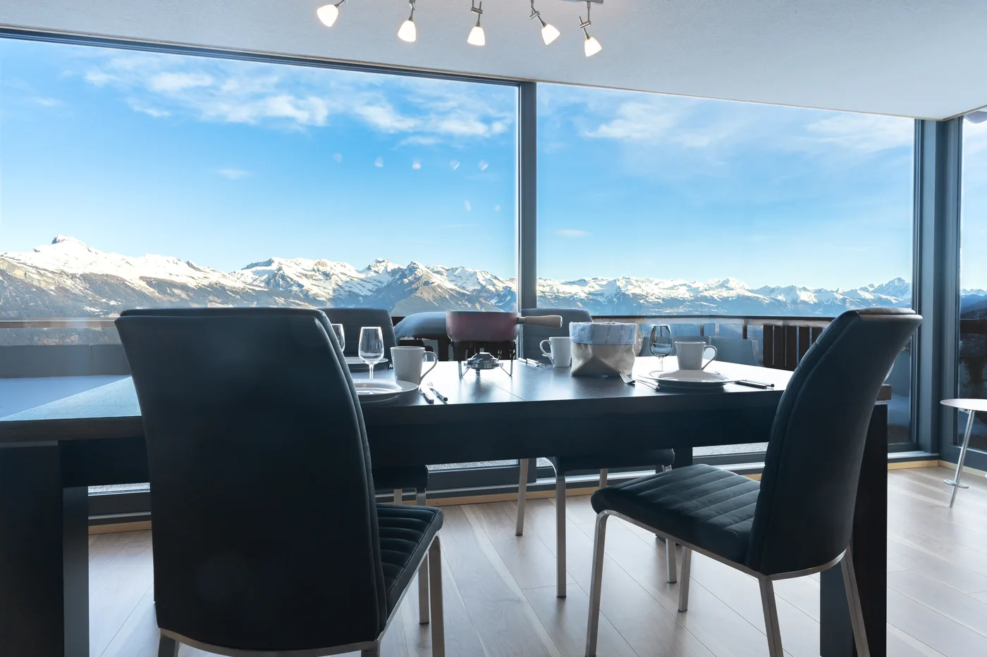 Table à manger face à la baie vitrée panoramique d'un appartement en gestion locative