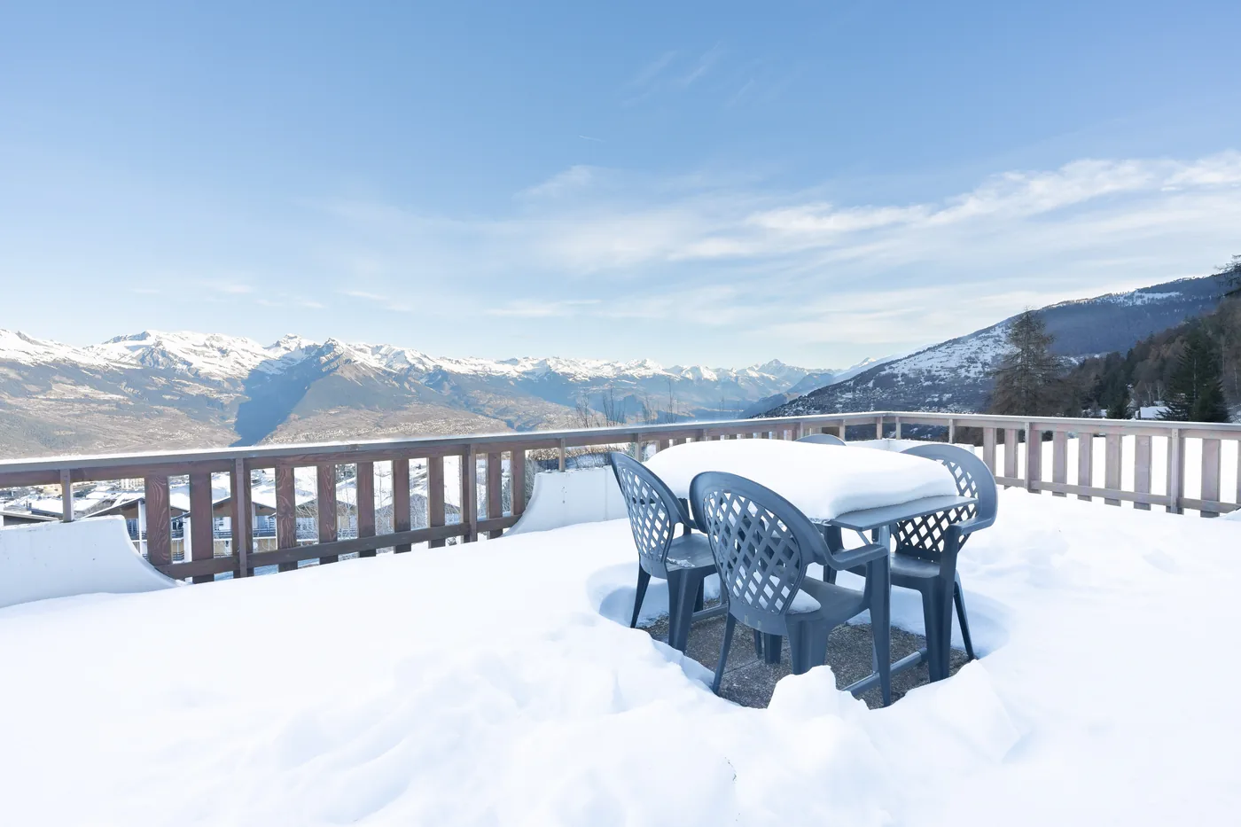 Terrasse enneigée avec vue sur la vallée du Rhône d'un appartement en gestion locative
